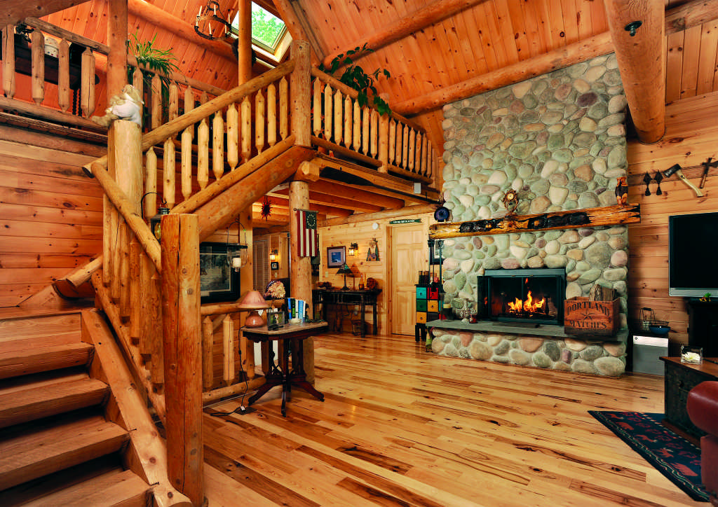 Maine log home interior staircase stone fireplace